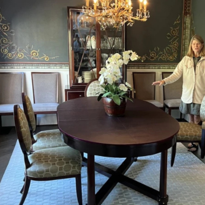 Elegant dining room with a light geometric-patterned area rug under a dark wood oval table and upholstered chairs.